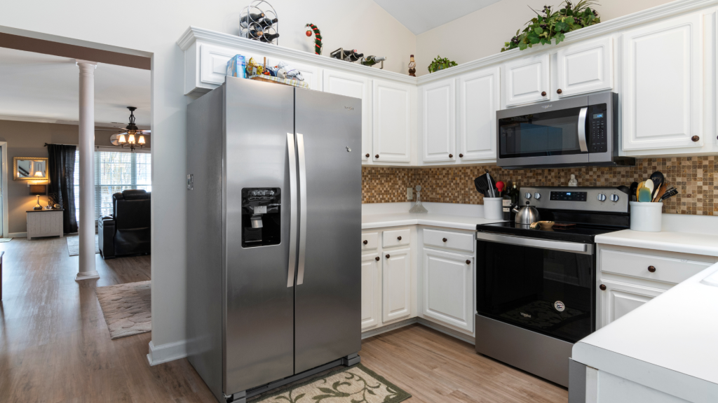 A photo of a modern home kitchen with a livingroom in the background